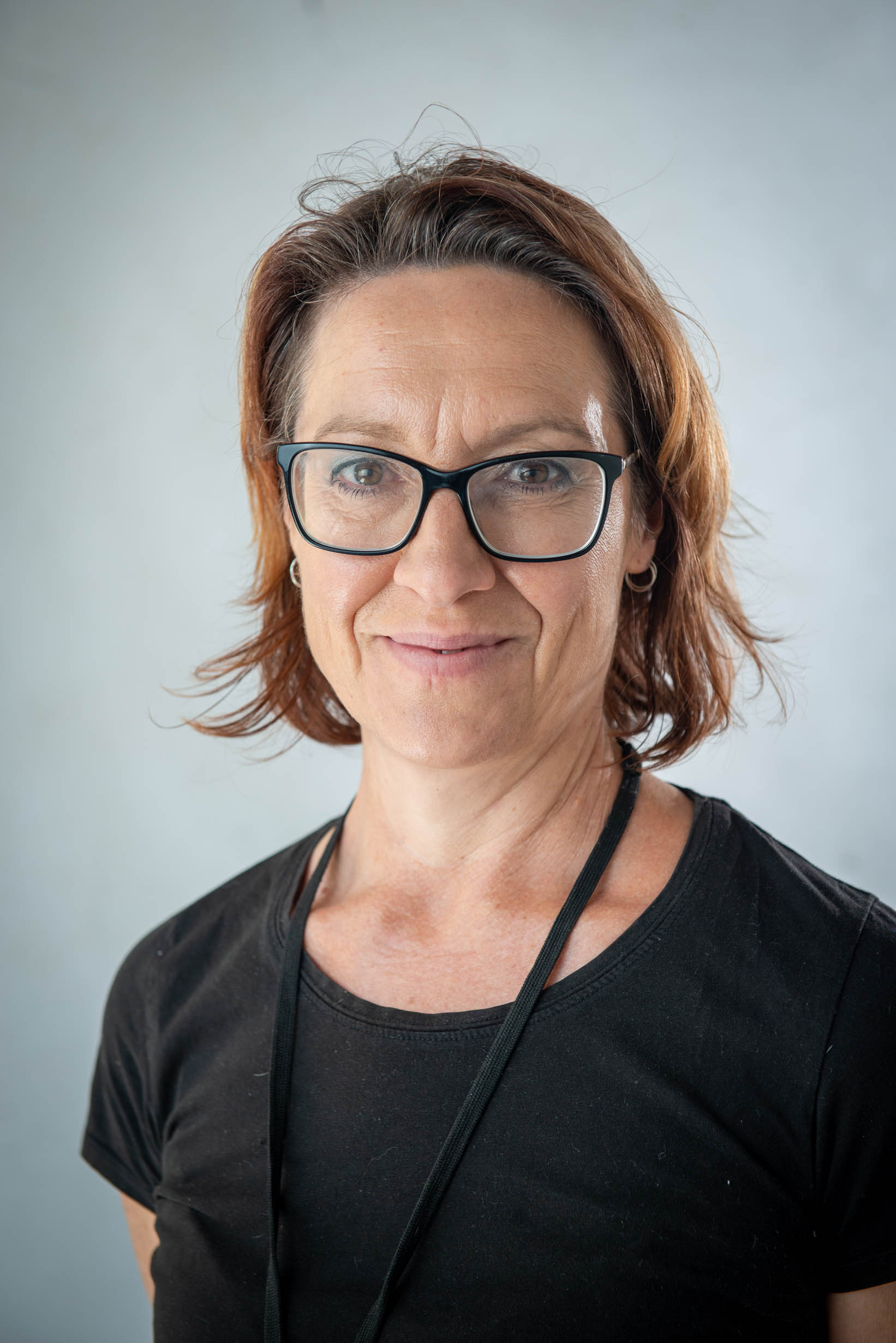 A woman wearing glasses smiles